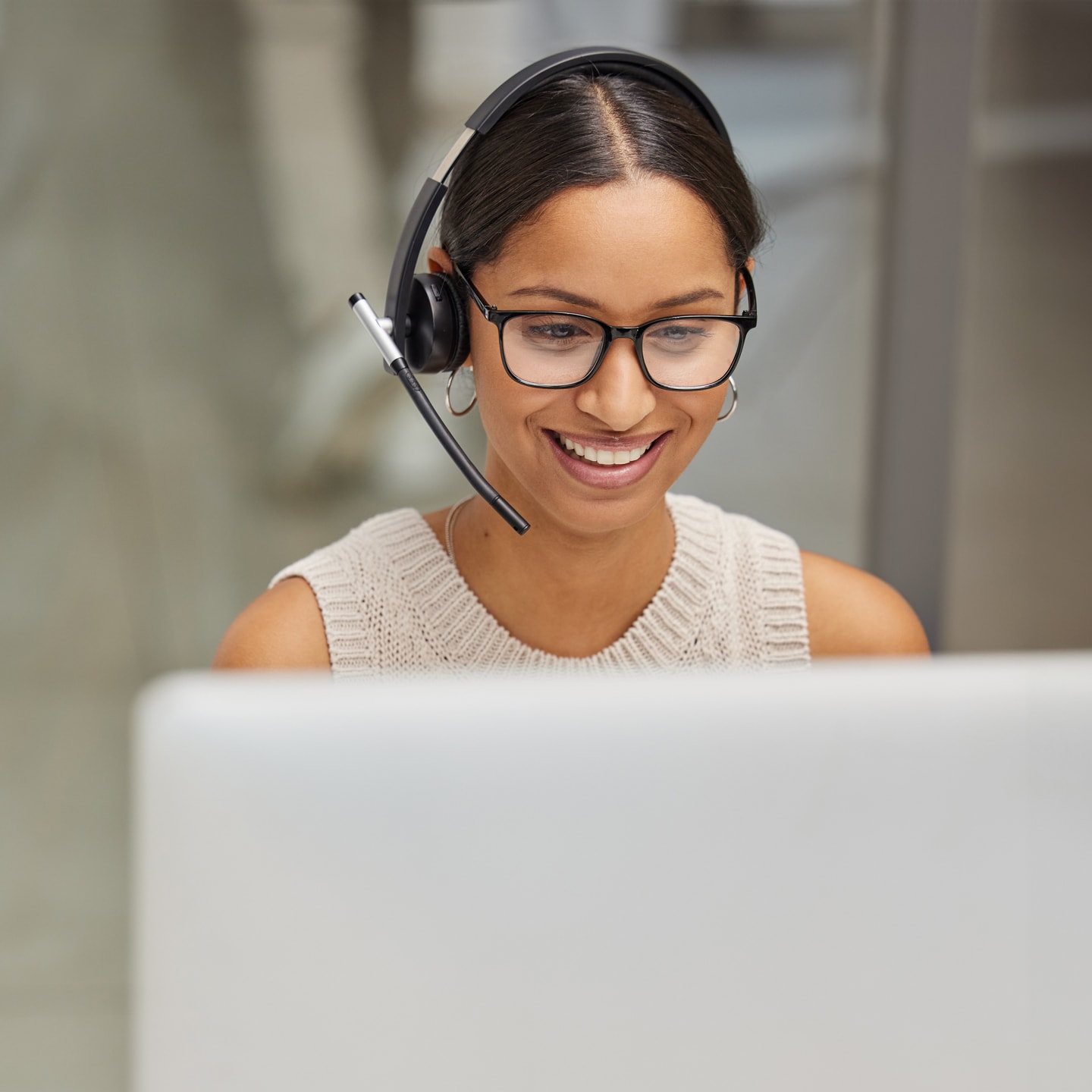 Agente de servicio al cliente ayudando a alguien con sus auriculares y su computadora.